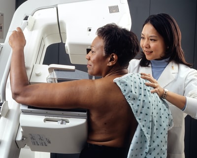 女医生站在女病人旁边做乳腺癌筛查